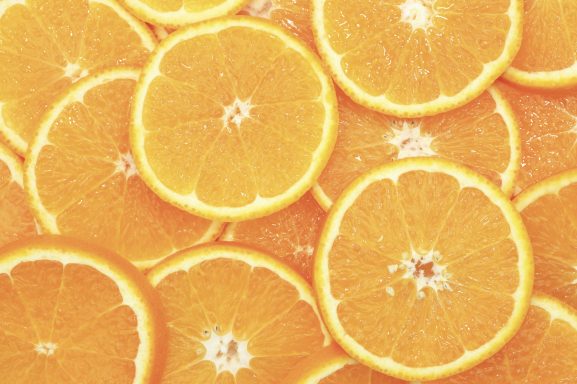 Orangen Scheiben von frischen Orangen, gleichmäßig übereinandergelegt und leuchtend orange.